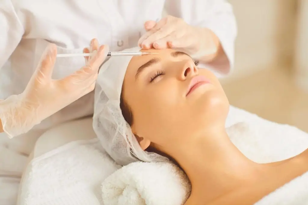 Cosmetology doctor makes beauty injections on face to a woman