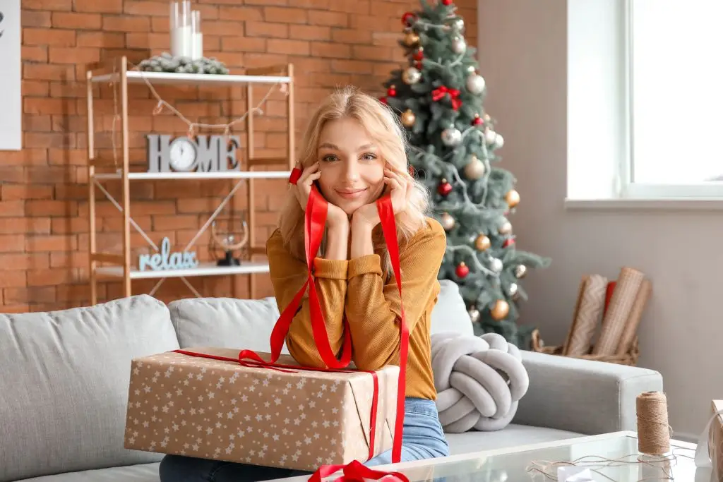 woman wrapping christmas presents at home